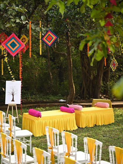 Comfortable and colorful seating arrangements for a garden Haldi ceremony. We use bright yellow fabrics and pink cushions to create a festive and relaxed atmosphere for guests.
