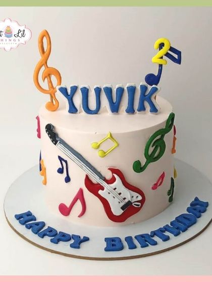 A rockstar's 2nd birthday cake! This music-themed creation is decorated with a guitar and colorful musical notes.