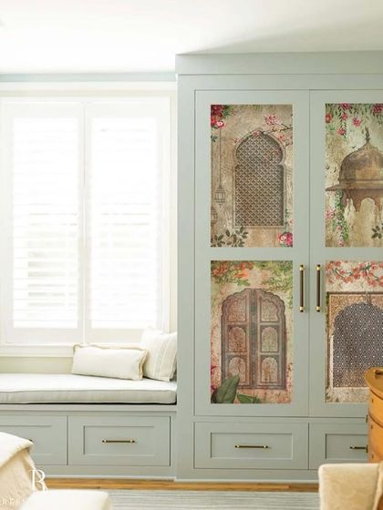 A wardrobe transformed into a piece of art with custom wallpaper panels. This design features motifs of traditional Indian architecture, like jharokhas and carved doors, adding a touch of heritage and classic charm.