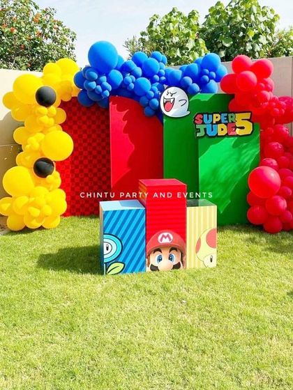 An outdoor Super Mario themed birthday party. This creative setup uses colorful backdrops and themed boxes to recreate the world of the popular video game.