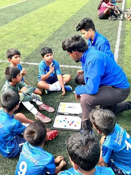Coaching is more than just drills; it's about strategy and mentorship. Here, our coaches discuss tactics with the U-9 football team during a break, ensuring every player understands their role on the field.