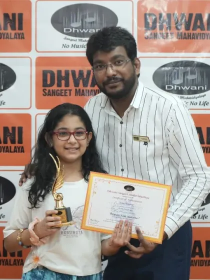 A teacher congratulates his student on her well-deserved award.