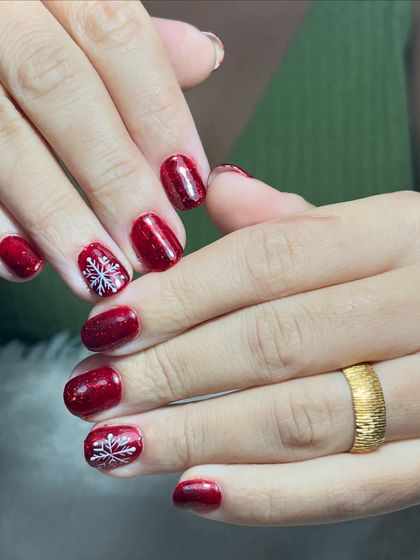 A full view of the sparkling red snowflake nails. This is a great option for someone who wants a touch of holiday spirit without a full set of intricate art.
