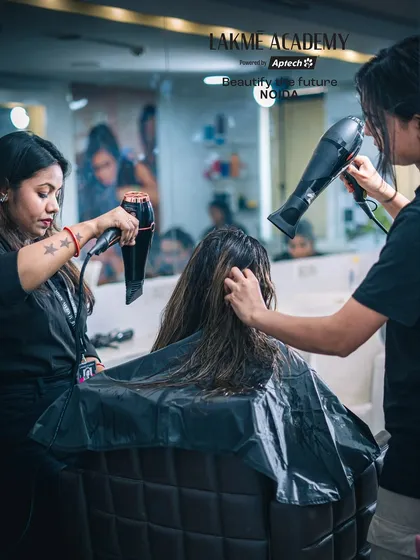 Students practicing blow-drying techniques during a hair treatment workshop. This is a crucial skill for achieving a flawless, smooth finish.