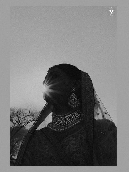 An artistic black and white silhouette of the bride against the sun. The sunburst effect creates a powerful and dramatic image that is both abstract and deeply emotional.