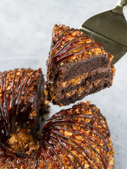 A close up of my popular Chocolate Praline Crunch cake. You can see the layers of rich chocolate sponge, smooth mousse, and the satisfying crunch of caramelized nuts. It’s a reminder that even a single slice can be a celebration.