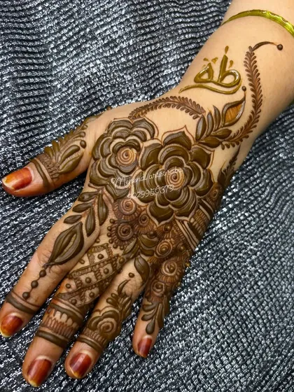 A beautiful single-hand design featuring shaded roses and leaves, with a name in Arabic script on the wrist.