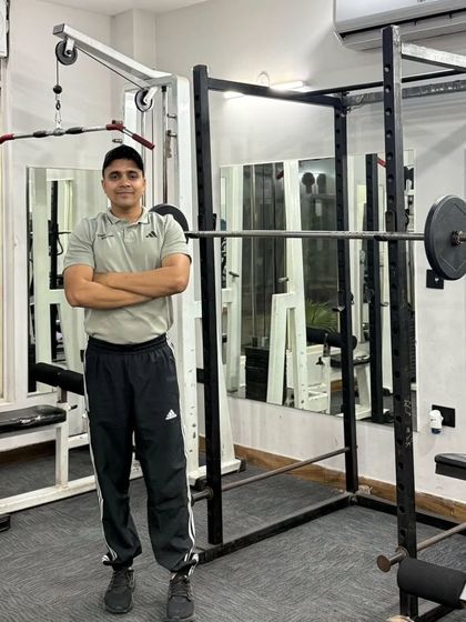 Arms crossed in front of the squat rack.