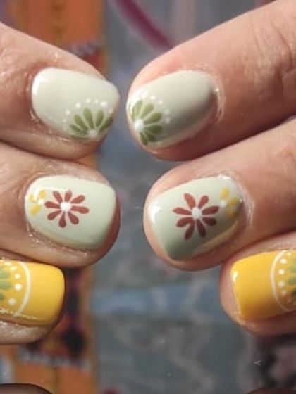A detailed close-up of the charming, hand-painted folk art nails.