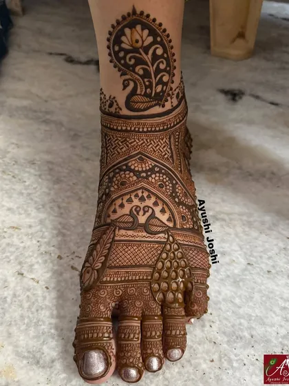Bridal mehendi isn't complete without decorating the feet. This is an example of a full, intricate design for the feet, featuring graceful swans and peacock motifs to match the bride's hands.