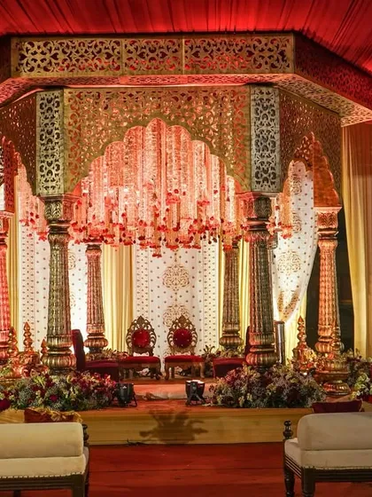 This mandap was designed as a royal court, featuring intricately carved gold pillars and a jharokha-style canopy with a breathtaking chandelier of crystal strings and red roses.