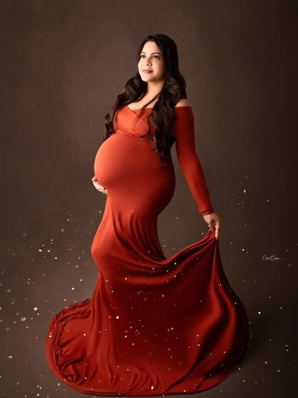 A sprinkle of magic enhances the glow of this mom-to-be in her form-fitting burnt-orange gown.
