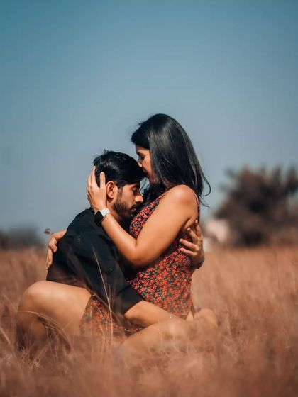 A tender embrace in a golden field, showcasing a moment of quiet connection. Our focus is on capturing the genuine emotion between you and your partner during your portrait session.
