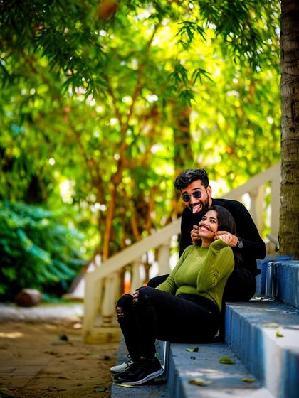 A playful and cute moment on a set of blue stairs, with the groom making a funny face, capturing the couple's lightheartedness.