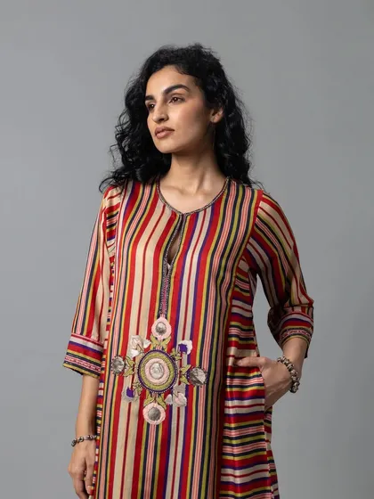 This striped kurta set features a beautiful medallion of embroidery at the center, blending multiple colors and textures for an artistic feel.