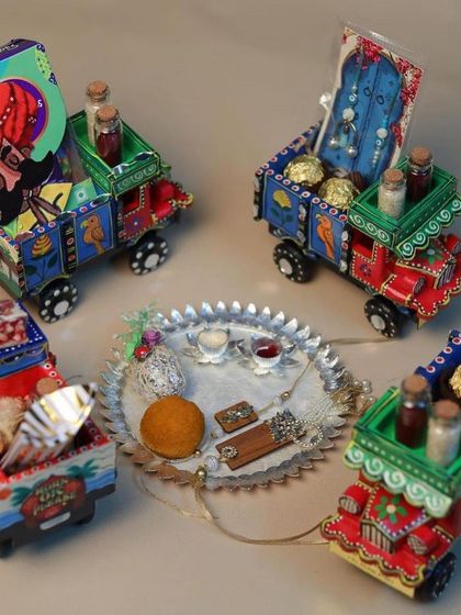 A collection of our 'Desi Gaddi' Rakhi hampers, each one uniquely painted and filled with goodies.