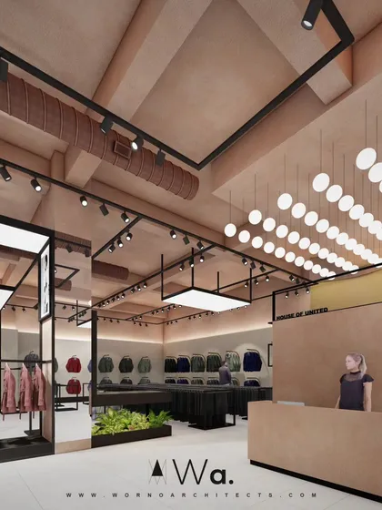 This angle of the retail store highlights the layered lighting design, from the spherical pendants to the track lights and backlit displays. This approach creates depth and visual interest throughout the space.