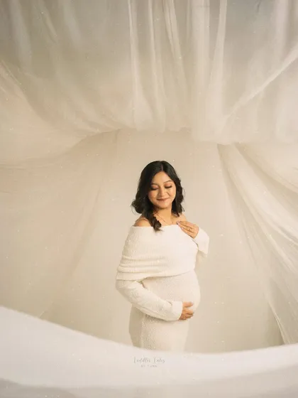 Wrapped in serenity and soft white fabrics, this portrait captures the quiet elegance of waiting. My minimalist sessions are perfect for mothers who desire a calm, dreamy, and timeless aesthetic, focusing purely on the beauty of the bump and the glow from within.