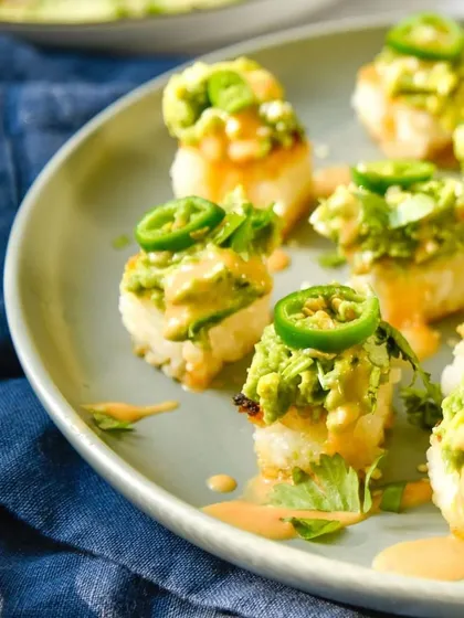 A plate of our spicy avocado crispy rice, a popular item from our Asian menu. Topped with jalapeños, it offers a perfect combination of texture and heat.