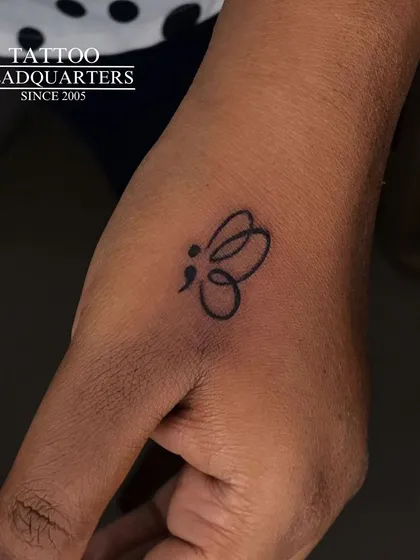 A semicolon butterfly tattoo on the hand, a powerful symbol of mental health awareness, resilience, and transformation.