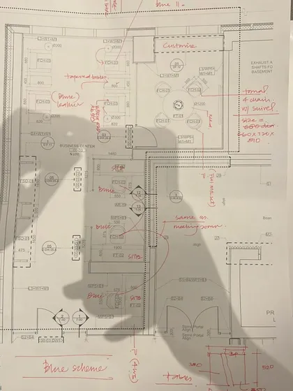An architectural plan marked with hand-written notes and shadows. This image represents the initial stage of design, where ideas are explored and spatial relationships are first defined on paper.