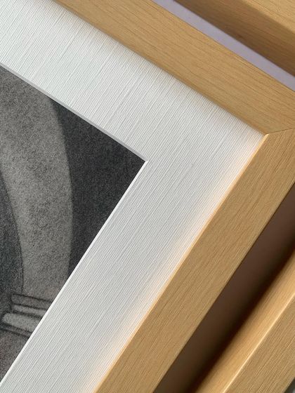 Another detail shot, highlighting the texture of the white mat board against the smooth maple wood frame.
