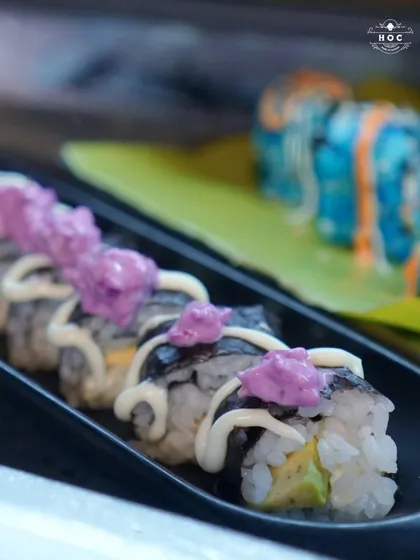 Another example of our creative vegetarian sushi, this time featuring a classic roll topped with a vibrant purple sauce and creamy mayonnaise, showcasing our flair for presentation.