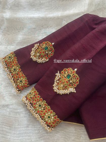 A deep wine-colored blouse with elegant kemp stone motifs on the sleeves.