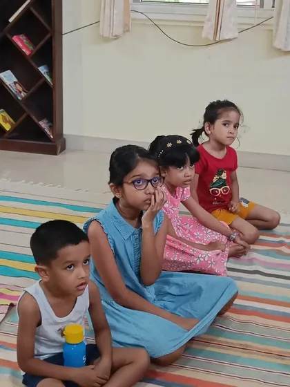 Children sit patiently, their eyes fixed on the storyteller, eager for the tale to begin.
