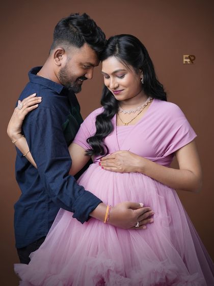 An intimate portrait focusing on the couple's connection. The soft pink gown and the gentle embrace create a feeling of warmth and love.