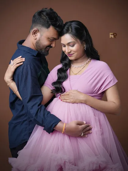 An intimate portrait focusing on the couple's connection. The soft pink gown and the gentle embrace create a feeling of warmth and love.