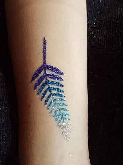 An elegant leaf design with a blue-to-white glitter gradient. This shows how I can blend colors to create a unique and artistic temporary tattoo.