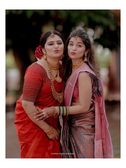 A playful moment between the bride and her bridesmaid, capturing the fun and friendship of the day.