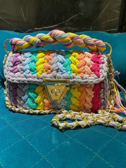 Another look at the rainbow marshmallow bag, showing off its vibrant colors against a solid background. Each color is carefully woven in to create this cheerful pattern.