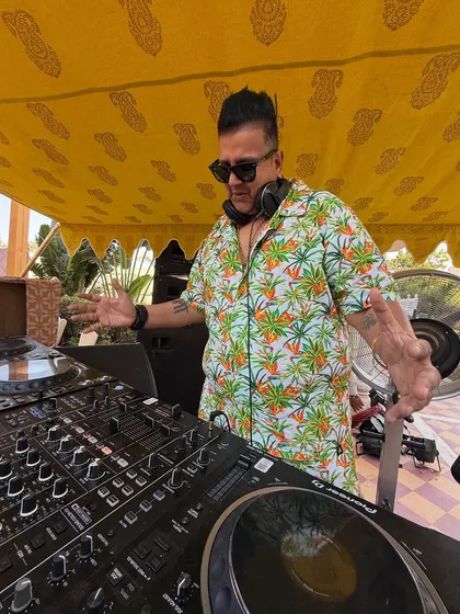 Energy, vibes, bass. A shot from behind the decks at a beautiful outdoor event, feeling the music and getting ready to make the crowd move.