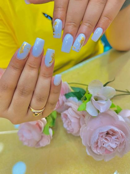 Another angle of the light blue and gold foil nails, showing the subtle texture of the foil.