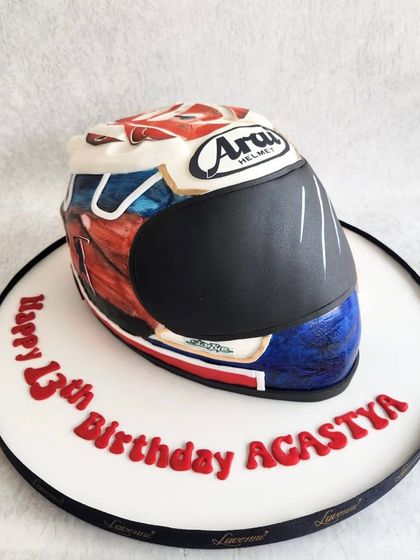A hand-painted Arai helmet cake for a biker's 13th birthday. This was a structural cake that required careful sculpting and detailed painting to replicate the original helmet design.
