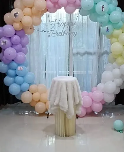 A pastel rainbow circular balloon arch, perfect for a soft and pretty party theme.