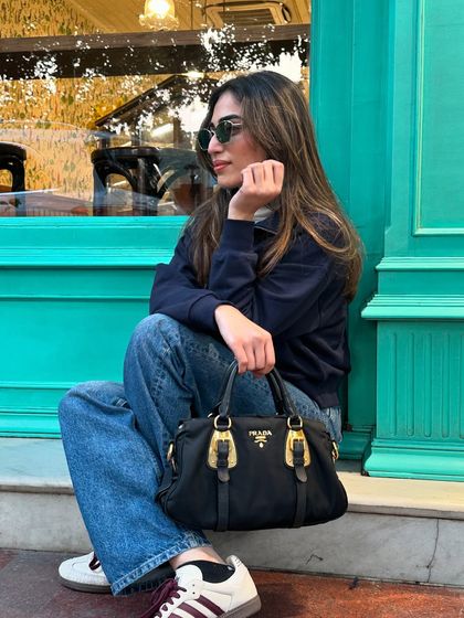 A closer look at the accessories for my casual winter outfit. A classic black Prada bag and sunglasses elevate the simple look.