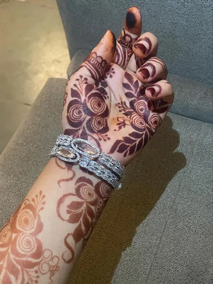 A fresh Gulf-style rose design on the back of the hand. The bold floral patterns and delicate vines are applied with precision using my handmade cones.