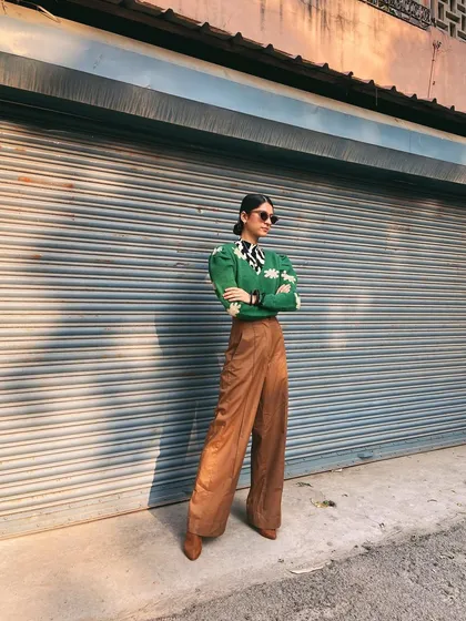 A street style look featuring a green sweater with daisy embroidery and wide-leg brown pants. This is a perfect example of my love for quirky details and comfortable silhouettes.