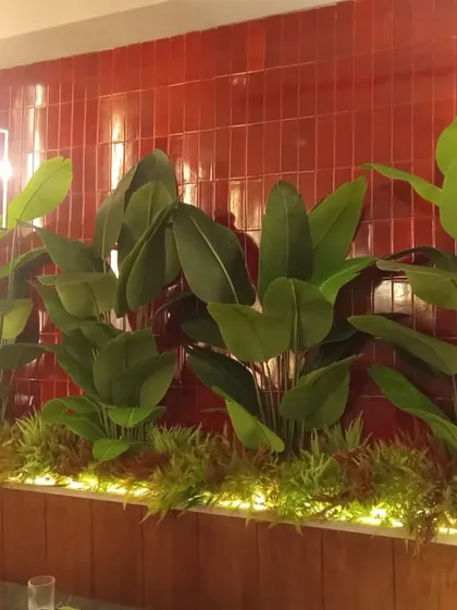 A wide view of the lit planter box in the restaurant, creating a stunning feature wall against the red tiles.