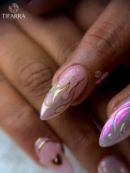 A detailed shot of our hand-drawn golden flame art. The fine lines and iridescent chrome effect create a dynamic and eye-catching design on this stiletto nail.