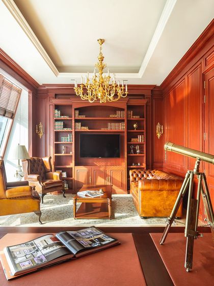 The rooftop director's office for Paras Buildtech is a workspace infused with opulence and sophistication. The neoclassical design features heavy veneer paneling, antique leather upholstery, and a grand chandelier, creating a commanding and luxurious environment.