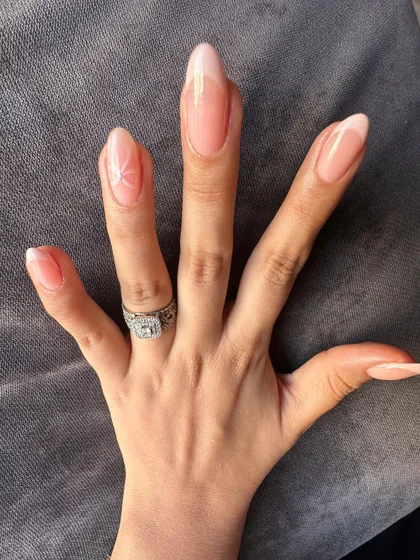 Sometimes, a single, tiny star is all you need to make a statement. A beautiful example of minimalist nail art on long extensions.