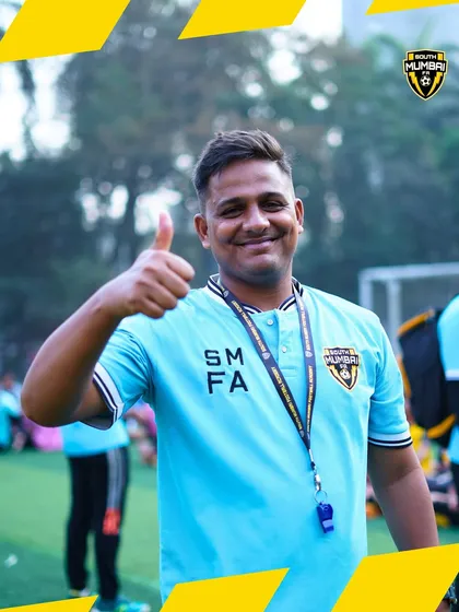 A thumbs-up from a coach on the training ground. This gesture reflects the supportive and motivational environment we cultivate at the academy.