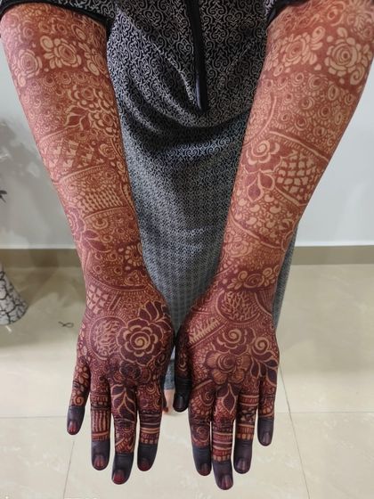 A full-arm view of a perfectly matured henna stain. You can see how the color is consistent and dark from the fingertips all the way to the elbows.