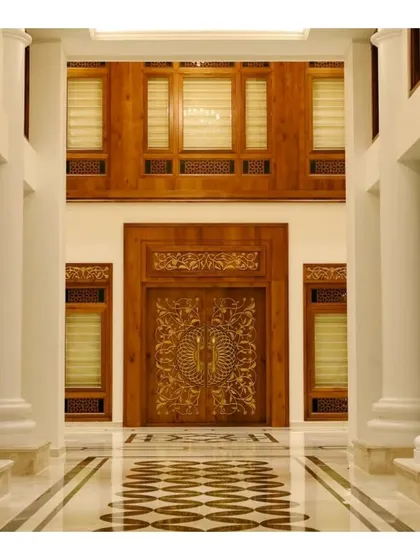 The entrance to a home should be a statement of what lies within. This intricately carved main door, crafted from solid wood, is the centerpiece of a Kerala-inspired residence, showcasing our passion for custom woodwork and traditional detailing.