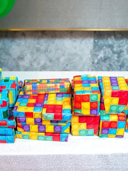 Return gifts wrapped in colorful LEGO brick-patterned paper.