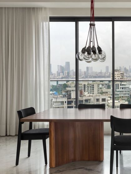 Another view of the Bayview dining space, where an industrial-style cluster of bulbs hangs over the table. This modern fixture adds a touch of drama without obstructing the panoramic view.